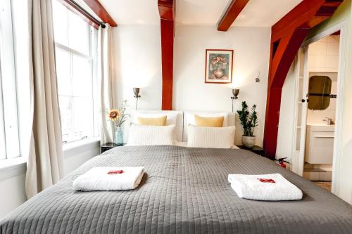 a bedroom with a large bed with two towels on it at Sunflower Amsterdam in Amsterdam