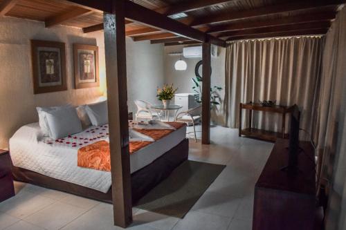 a bedroom with a bed and a table in it at Pousada Recanto do Lobo in Porto De Galinhas