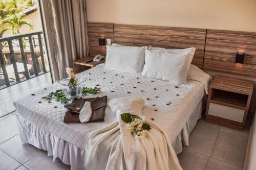 a bedroom with a bed with flowers on it at Pousada Recanto do Lobo in Porto De Galinhas
