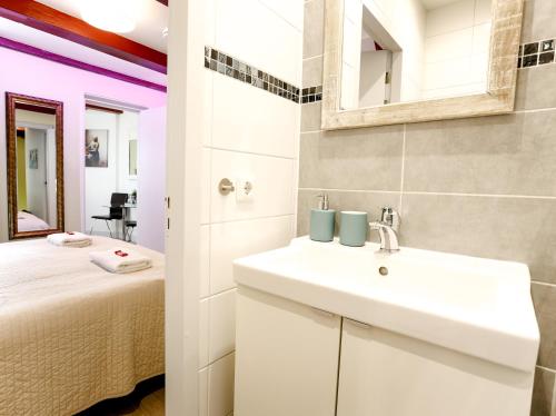 a bathroom with a sink and a bed in a room at Sunflower Amsterdam in Amsterdam