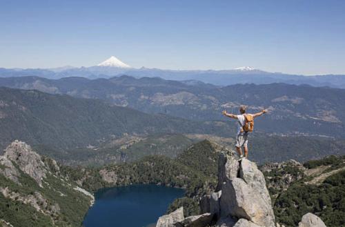 a man standing on top of a mountain with his arms outstretched at Pucon, la Capital del Sur de Chile in Pucón