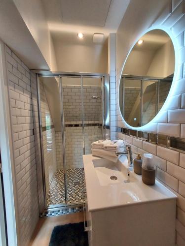 a bathroom with a shower and a sink and a mirror at Studio Exupere in Bayeux