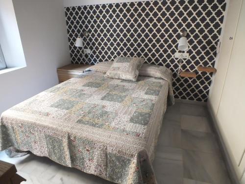 sypialnia z łóżkiem i wzorzystą ścianą w obiekcie Apartamento Sevilla Alhondiga w Sewilli