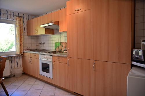 a kitchen with wooden cabinets and a stove at Haus Lisa Burg Dithmarschen am Nord Ostsee Kanal Nordsee in Burgerfeld