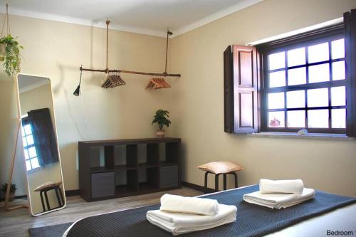una camera con due asciugamani su un letto con specchio di Casa Elias a Óbidos