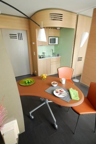 a room with a table and chairs and a kitchen at Aparthotel Adagio Bordeaux Centre Gambetta in Bordeaux
