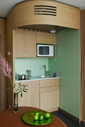 a kitchen with a table with a plate of fruit on it at Aparthotel Adagio Bordeaux Centre Gambetta in Bordeaux