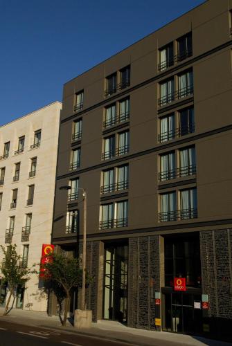 a large building on a city street next to a building at Aparthotel Adagio Bordeaux Centre Gambetta in Bordeaux