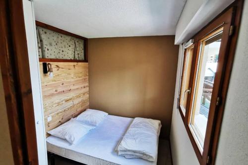 オーズにあるOz Appartement cosy 3 chambresの窓付きの小さな部屋の小さなベッド1台分です。