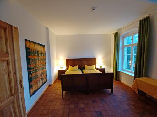 - une chambre avec un lit, deux lampes et une fenêtre dans l'établissement FeWo "Falter" im Kunstgut Krahne, à Krahne