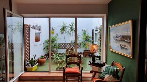 a room with a large window with chairs and plants at Hostal Real in San Juan del Puerto