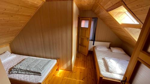 an attic room with two beds and a window at NAJBLIŻEJ MORZA DOM CAŁOROCZNY Jastarnia in Jastarnia