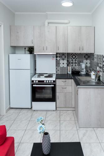 a kitchen with a white refrigerator and a stove at Kosta's Apartments in Vonitsa