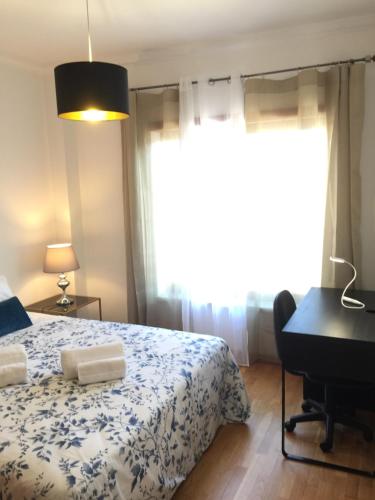 a bedroom with a bed and a desk and a window at Miguel Torga River in Coimbra