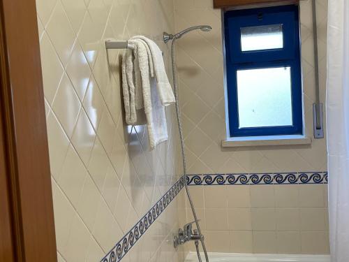 a bathroom with a shower with towels and a window at Miguel Torga River in Coimbra