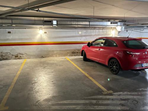 a red car parked in a parking garage at Miguel Torga River in Coimbra