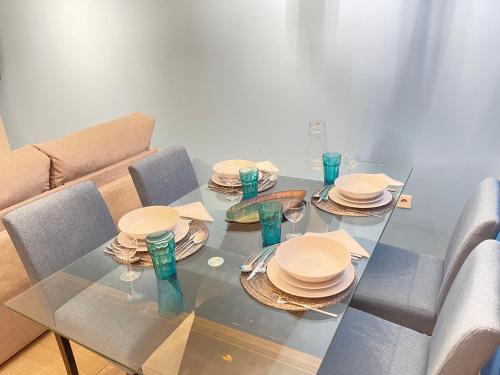 a glass table with plates and glasses on it at Miguel Torga River in Coimbra
