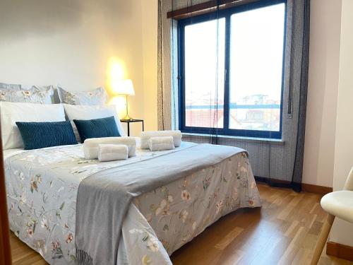 a bedroom with a large bed with a large window at Miguel Torga River in Coimbra
