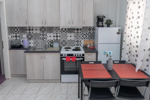 a small kitchen with a table and a refrigerator at Kosta's Apartments in Vonitsa