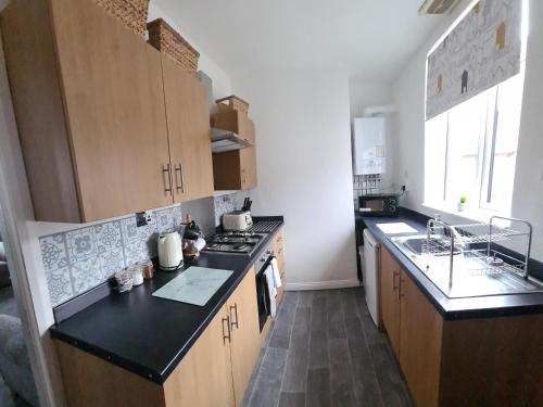 a kitchen with wooden cabinets and a black counter top at 1 Grange Street in Pelton