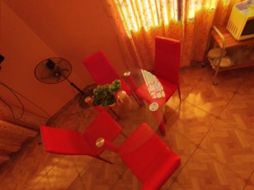 an overhead view of a glass table with red chairs at Travel House in Ica