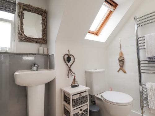 a bathroom with a sink and a toilet and a mirror at 61 Seatown in Buckie