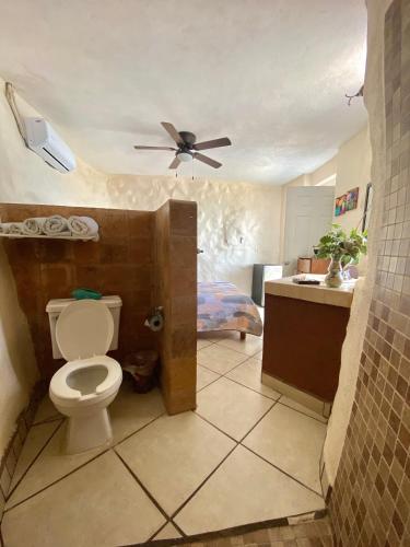 a bathroom with a toilet and a ceiling fan at Villa Paraíso in La Ventana