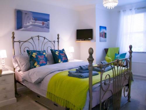 a bedroom with a bed with a yellow blanket at Stunning Seafront House with garden and private parking in Eastbourne