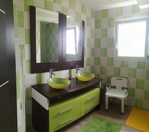 a bathroom with two sinks and two mirrors at B&B chez EVA en Périgord in Le Buisson de Cadouin