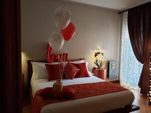 アオスタにあるLe Chat a Pois n 0232のベッドルーム1室(赤と白の風船が備わるベッド1台付)
