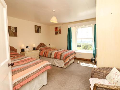 a bedroom with two beds and a window at The Barton in Bideford
