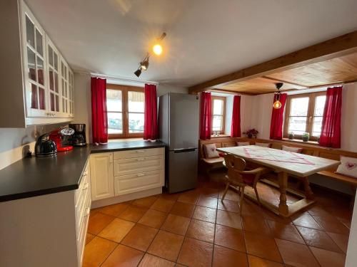 a kitchen with a table and a kitchen with red curtains at Bergien in Halblech