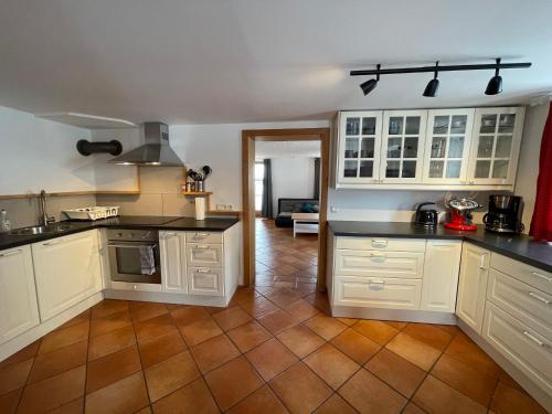 a kitchen with white cabinets and a tile floor at Bergien in Halblech