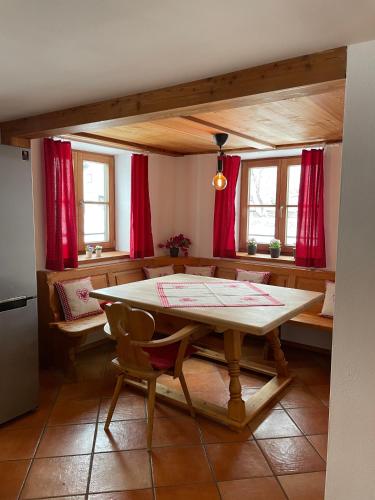 a dining room with a table and red curtains at Bergien in Halblech