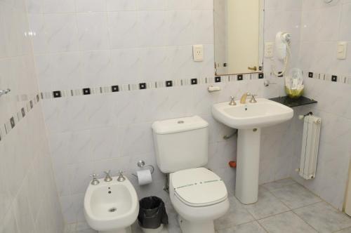 La salle de bains blanche est pourvue de toilettes et d'un lavabo. dans l'établissement Hotel Hoxon, à Luján