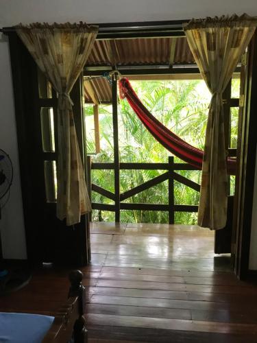 an open door to a room with a hammock at FLOR DE PARAISO BUNGALOWS in Montezuma