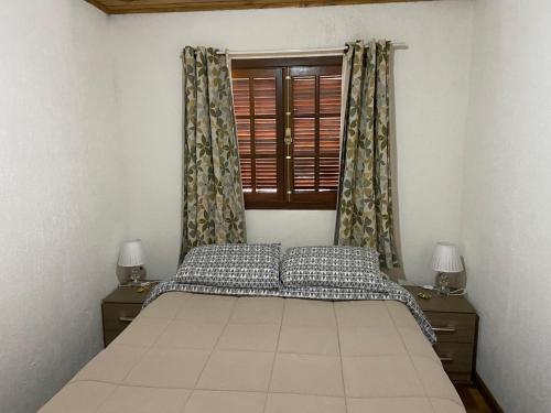 una camera con letto e finestra con tende di Cantinho da alice a Campos do Jordão