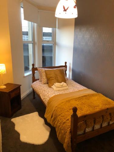 a bedroom with a bed and a lamp and two windows at Exclusive rooms in a beautiful home - big grups in Bristol