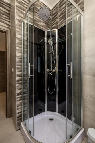 a shower with a glass enclosure in a bathroom at Apartments Vila Belvedere in Rijeka