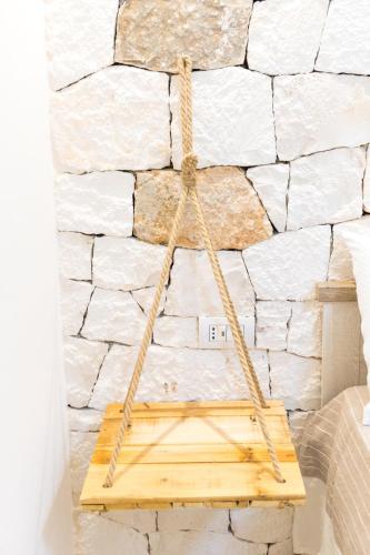 a wooden triangle hanging on a stone wall at Villa Luis in Fasano