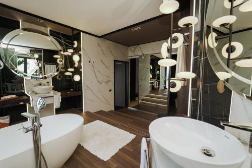 a bathroom with a white tub and a sink at Makanda by The Sea Hotel Adults Only in Manuel Antonio