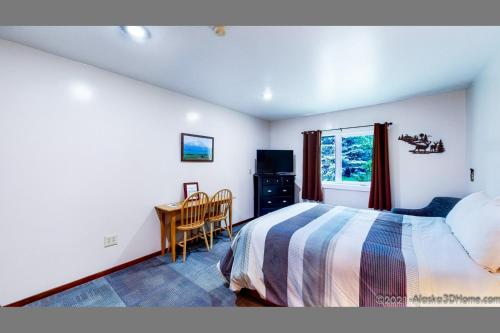 a bedroom with a bed and a desk and a window at Backwoods Lodge in Cantwell