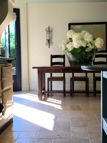 uma sala de jantar com uma mesa com um vaso de flores em The Pebble Bed and Breakfast em Halifax