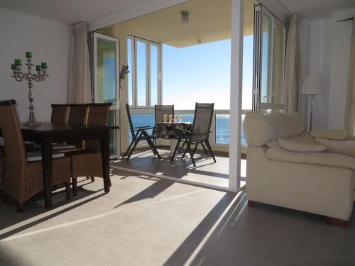 sala de estar con piano y mesa con sillas en Belvilla by OYO Apartament Altea Mar, en Altea