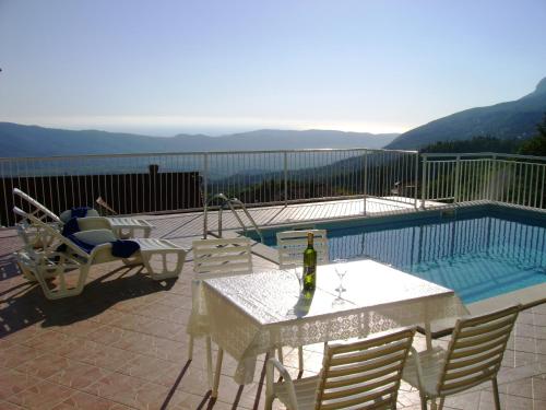 a patio with a table and chairs next to a pool at Holiday Home Urlović in Gruda