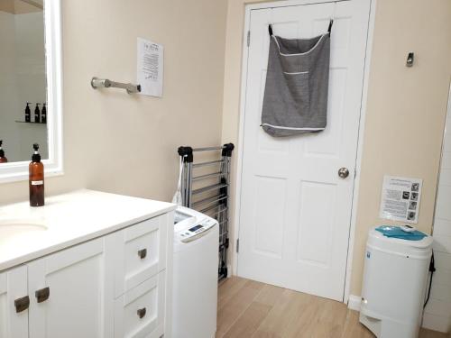 a bathroom with a sink and a white door at Keep Cool Guesthouse in Gros Islet