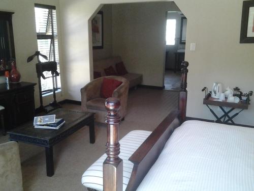 a bedroom with a bed and a living room at Fairways Hotel in Ballito