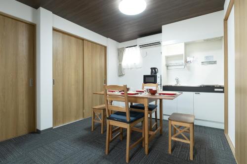 een keuken en eetkamer met een tafel en stoelen bij NAGAHORI HAIRU DOTONBORI CONDO in Osaka