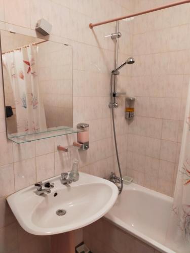 a bathroom with a sink and a mirror and a tub at Cantinho do Zé e da Júlia in Lagos
