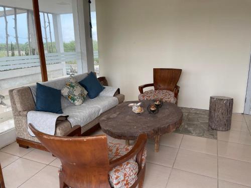 a living room with a couch and a table and chairs at Luna Roja casa Frente al Mar y glamping in San Onofre